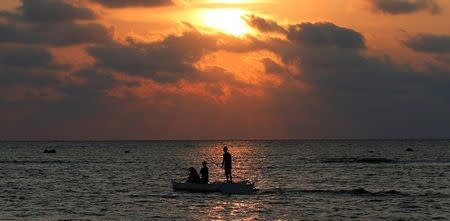 Philippine fishermen steers a dinghy during sunset as they fish inside the shoal of the disputed Scarborough Shoal April 5, 2017. REUTERS/Erik De Castro