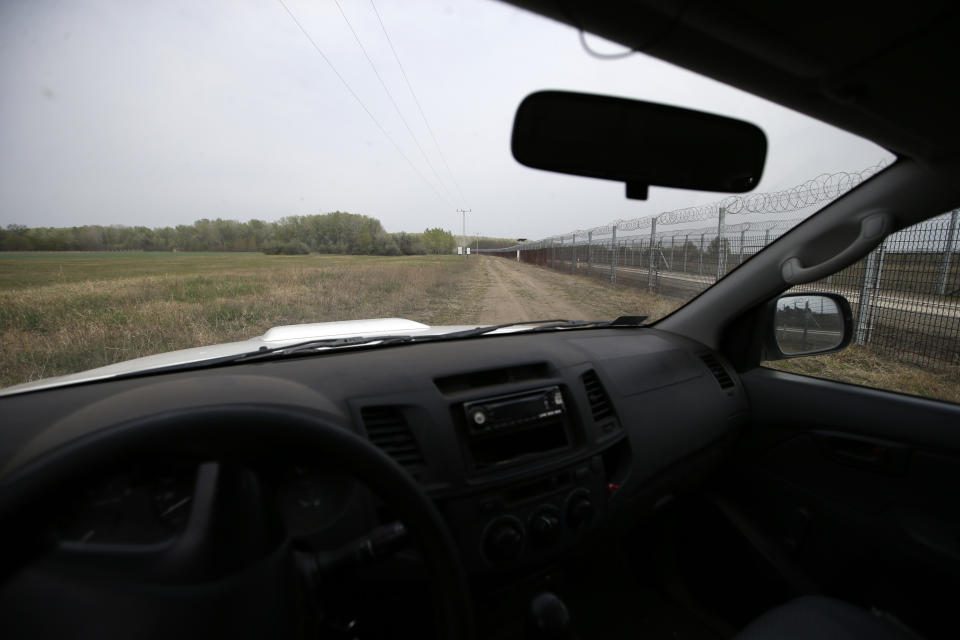 In this photo taken on Monday, April 8, 2019, a Hungarian rangers car travels along the fence at Hungary's border with Serbia near the village Asotthalom, Hungary. With a campaign centered on stopping immigration, Hungary’s ruling Fidesz party is expected to continue its dominance in the European Parliament election at the end of May. While Hungary has been practically closed to immigrants from the Middle East, Asia and Africa since Prime Minister Viktor Orban had border fences built in 2015, he continues to warn voters about the threat of a “migrant invasion” that would put at risk Europe’s Christian culture. (AP Photo/Darko Vojinovic)