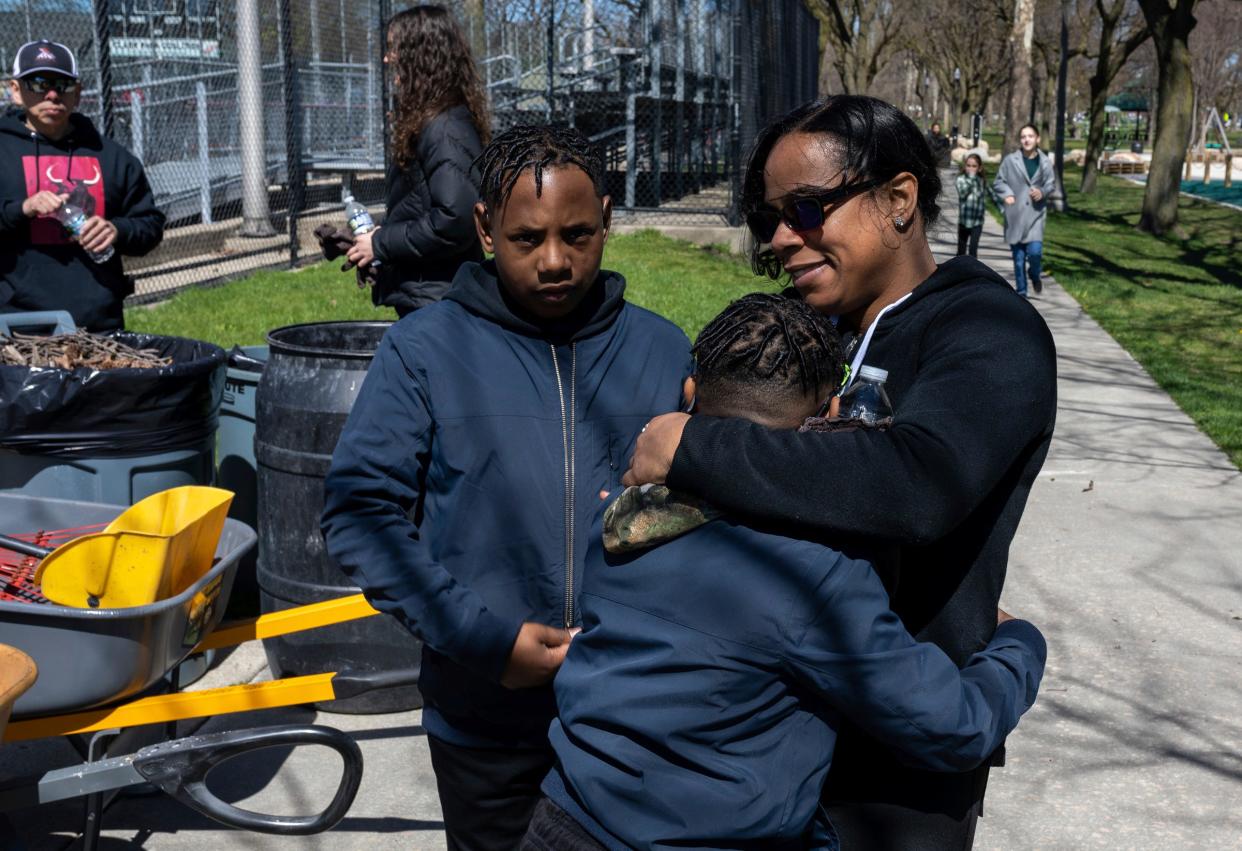 Dessinae Houston, an employee with the Housing and Revitalization Department at the city of Detroit, hugs her children after helping clean Clark Park in southwest Detroit on Saturday, April 13, 2024.