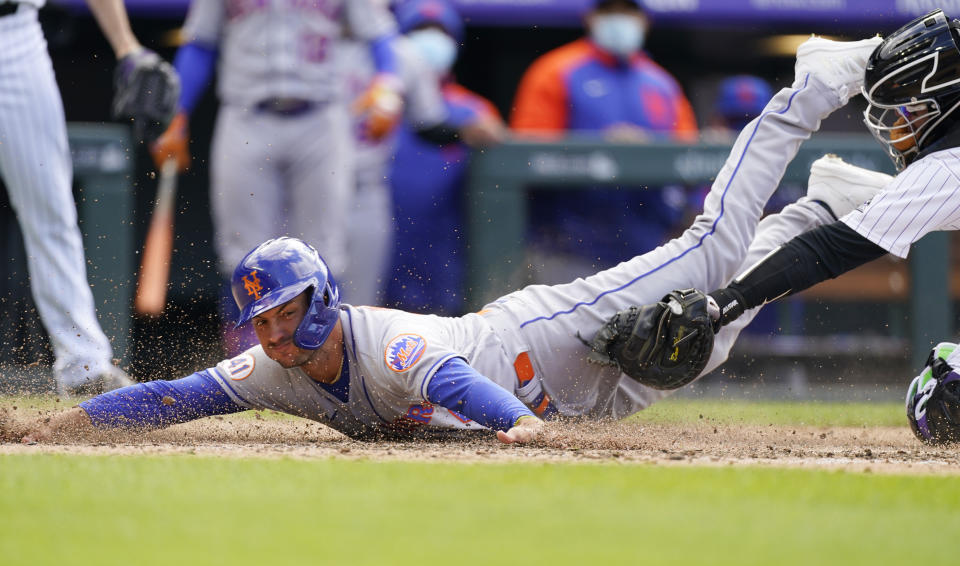 New York Mets pinch-runner Albert Almora Jr. scores on a pinch-hit double by Jonathan Villar as Colorado Rockies catcher Dom Nunez applies a late tag in the seventh inning of baseball game Saturday, April 17, 2021, in Denver. The Mets won 4-3 in the first game of a doubleheader. (AP Photo/David Zalubowski)