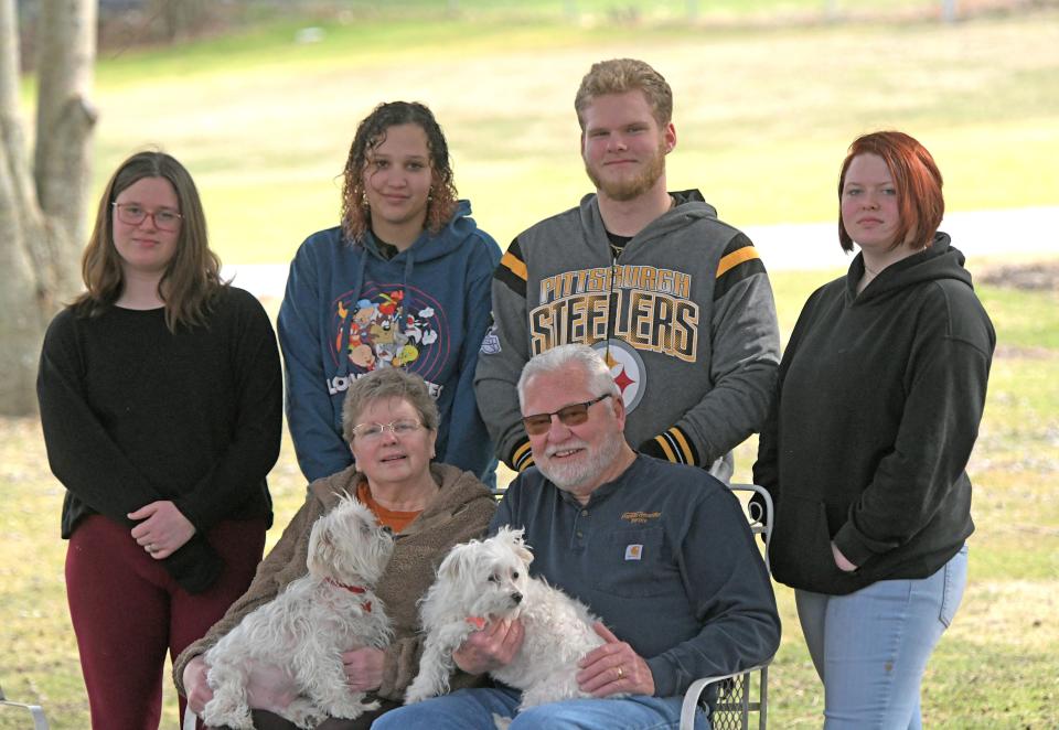 Melinda and Jim Shaum, sitting, have formed a family with, from left, Aven, Lia, Nick and Alivia Daisy. Their dogs Daisy, a Maltese, and Scampy, a Maltipoo are also part of the family.