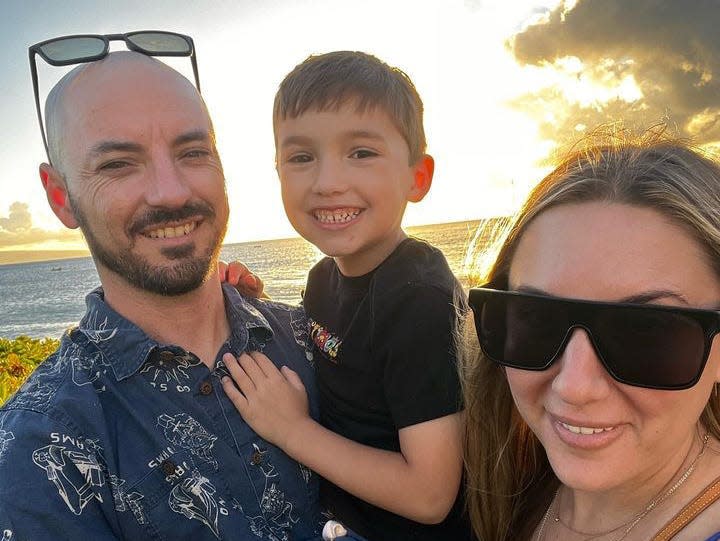 A family stands in front of a sunset in Maui, Hawaii.