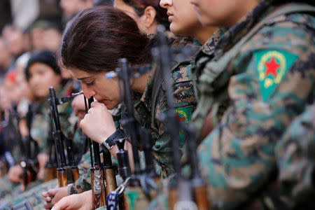 A Kurdish female fighter of the Women's Protection Unit (YPJ) gestures as she sits in the Sheikh Maksoud neighbourhood of Aleppo, Syria February 7, 2018. Picture taken February 7, 2018. REUTERS/Omar Sanadiki