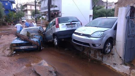 People stand next to piled up vehicles after a storm in Kalamata, Greece September 7, 2016. Eurokinissi/Dimitris Plemmenos via REUTERS