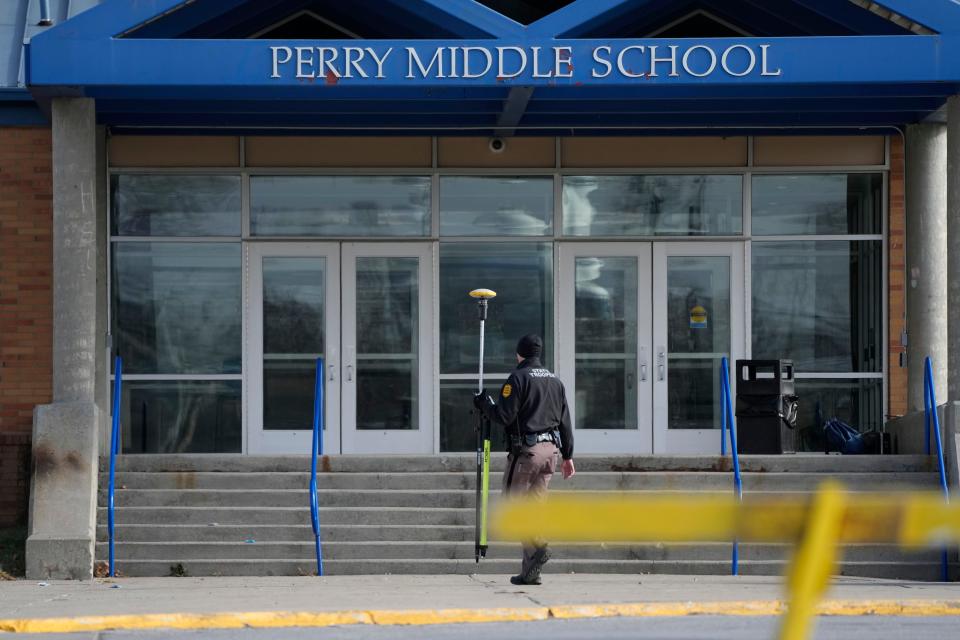 A law enforcement official walks past the Perry Middle School entrance following a shooting at the nearby Perry High School, Thursday, Jan. 4, 2024, in Perry, Iowa. Multiple people were shot inside the school early Thursday as students prepared to start their first day of classes after their annual winter break, authorities said. (AP Photo/Charlie Neibergall)