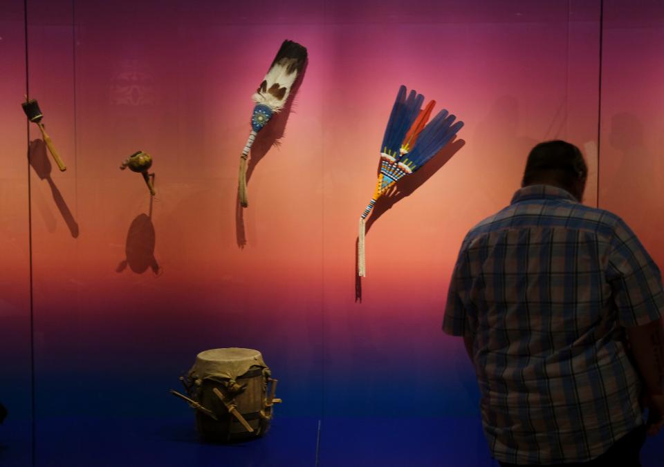 A man looks on Sept. 18, 2021, at items in the exhibit "WINIKO: Life of an Object" during the opening day of the First Americans Museum.