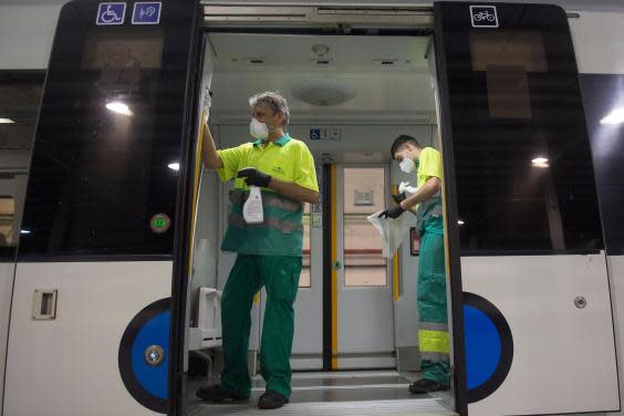 Employees carry out a disinfection of a train of the Basque railway company Euskotren in the Spanish Basque city of Irun in May 2020 (Photo by ANDER GILLENEA/AFP via Getty Images)