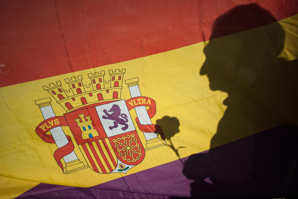 Silueta sujetando una flor sobre una bandera española republicana.