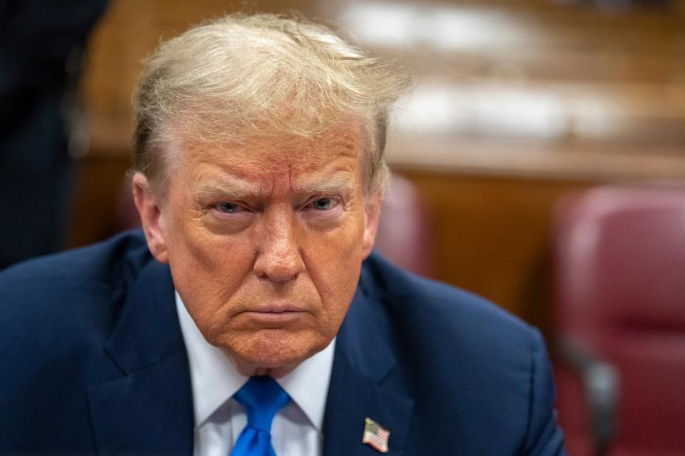 An angry-looking Mr Trump waits for the start of the third day of jury selection (AP)