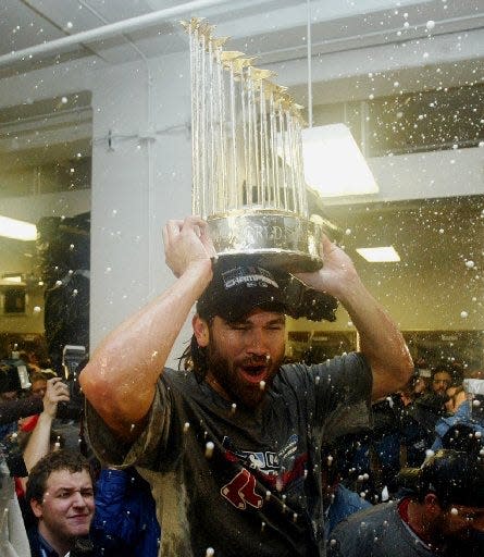 Boston Red Sox's Johnny Damon celebrates with the World Series trophy in the locker room after the Red Sox defeated the St. Louis Cardinals 3-0 in Game 4 of the World Series to sweep the Series, Wednesday Oct. 27, 2004 in St. Louis.