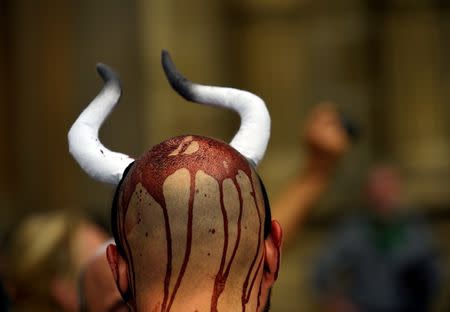 An animal rights protester covered in fake blood demonstrate for the abolition of bull runs and bullfights a day before the start of the famous running of the bulls San Fermin festival in Pamplona, northern Spain, July 5, 2016. REUTERS/Eloy Alonso