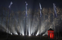 FILE-In this file photo taken Jan. 27, 2020, flags with the stripes pattern of prison uniforms of Nazi German death camps fly at the fence of the Auschwitz-Birkenau death camp in Oswiecim, Poland, during ceremony marking 75 years since the camp's liberation by the Soviet army. The camp's museum is objecting to a scene in the Amazon series "Hunters" that shows a game of murderous human chess, saying such a game never took place there. (AP Photo/Czarek Sokolowski)