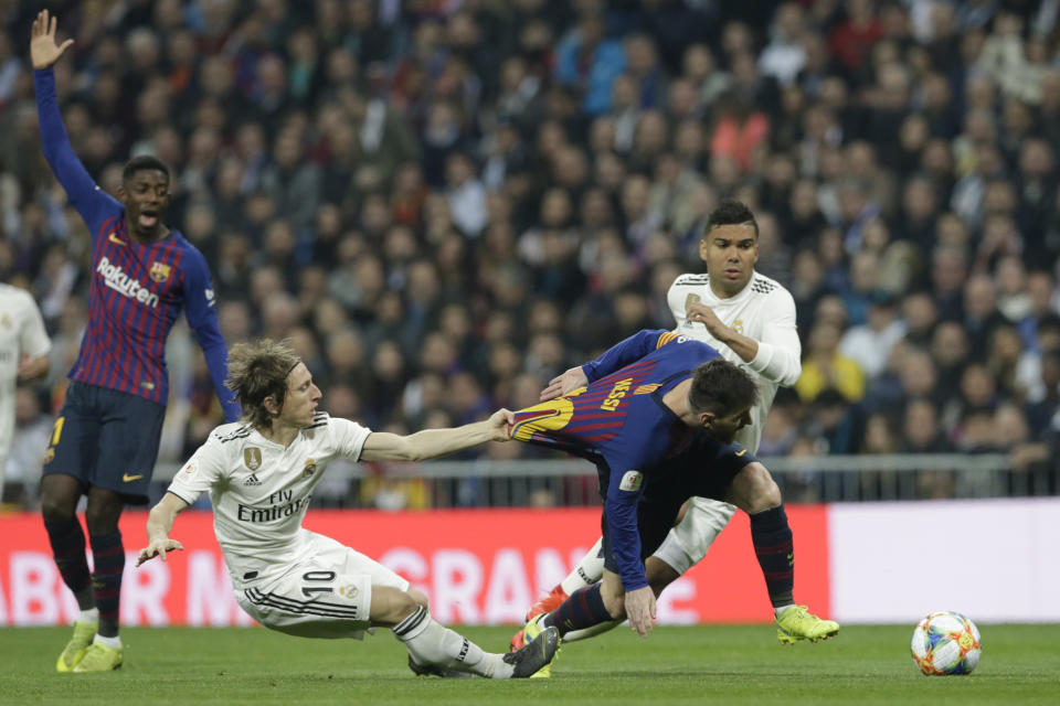 Barcelona forward Lionel Messi, right, is tackled by Real midfielder Luka Modric during the Copa del Rey semifinal second leg soccer match between Real Madrid and FC Barcelona at the Bernabeu stadium in Madrid, Spain, Wednesday Feb. 27, 2019. (AP Photo/Andrea Comas)