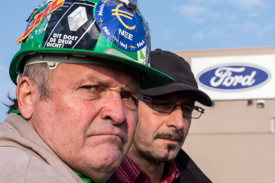 Ford workers react after the European Ford management announced it would close the Ford plant in Genk, Belgium on Wednesday Oct. 24, 2012. A union leader says Ford has decided to close its factory in Genk, Belgium, at the end of 2014 in a move that will result in 4,500 direct job losses and 5,000 more among subcontractors. (AP Photo/Geert Vanden Wijngaert)