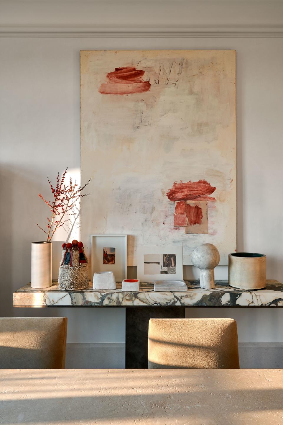A Breccia Stazzema marble-and-brass console by Dirand is topped with pieces by Robert Rauschenberg, Georges Jouve, Adrien Dirand, and André Borderie. Lawrence Carroll painting.
