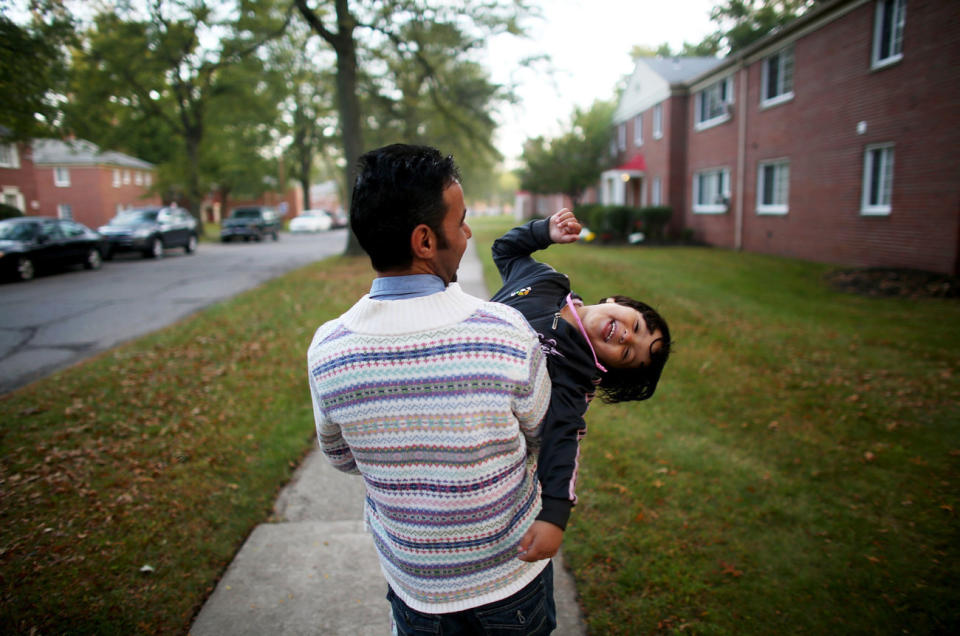 Omar Al-Awad holds his daughter as they walk home in Toledo, Ohio, where they were resettled after fleeing Syria and living in a Jordanian refugee camp. <i>From the story&nbsp;"<a href="http://www.npr.org/2015/10/20/450221327/among-the-lucky-few-syrian-family-rebuilds-in-americas-heartland" target="_blank">Among The Lucky Few: Syrian Family Rebuilds In America's Heartland</a>," 2015.</i>