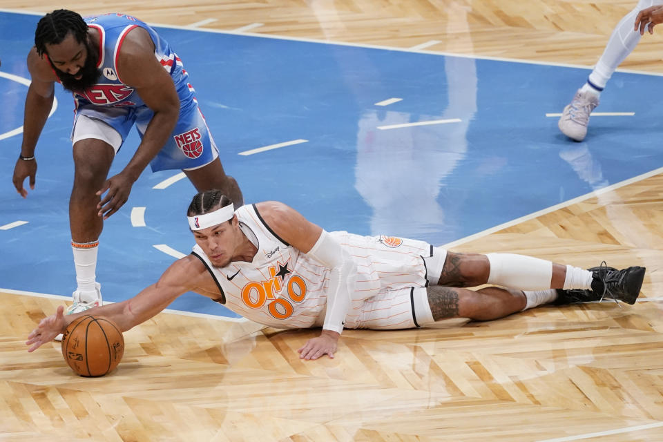 Brooklyn Nets guard James Harden (13) and Orlando Magic forward Aaron Gordon (00) vie for a loose ball during the first half of an NBA basketball game, Saturday, Jan. 16, 2021, in New York. (AP Photo/Mary Altaffer)