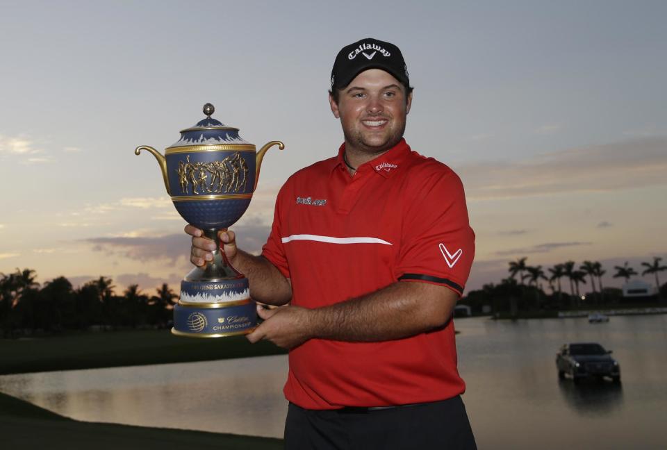 Patrick Reed holds The Gene Sarazen Cup after winning the Cadillac Championship golf tournament Sunday, March 9, 2014, in Doral, Fla. (AP Photo/Wilfredo Lee)