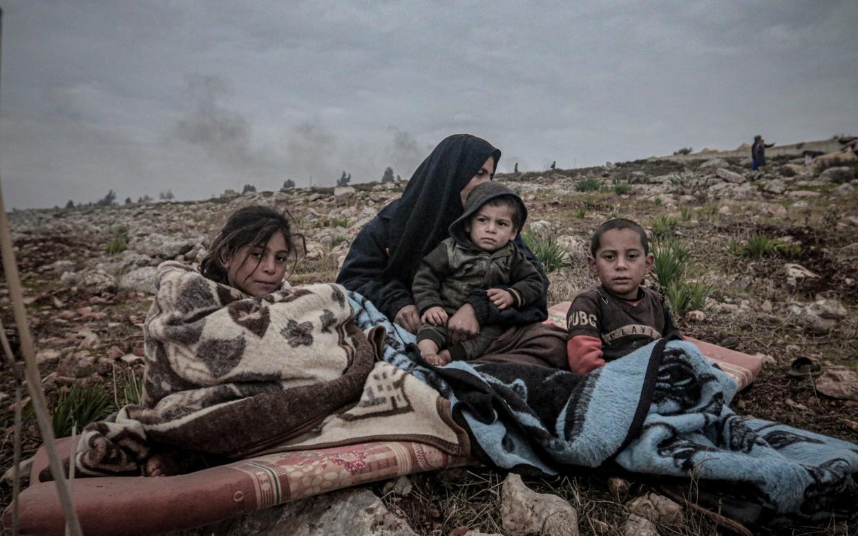 Syrians displaced by the ongoing attacks carried out by the Assad regime and Russia, seek refuge in a makeshift tent area in Harbanos town of Idlib - Anadolu