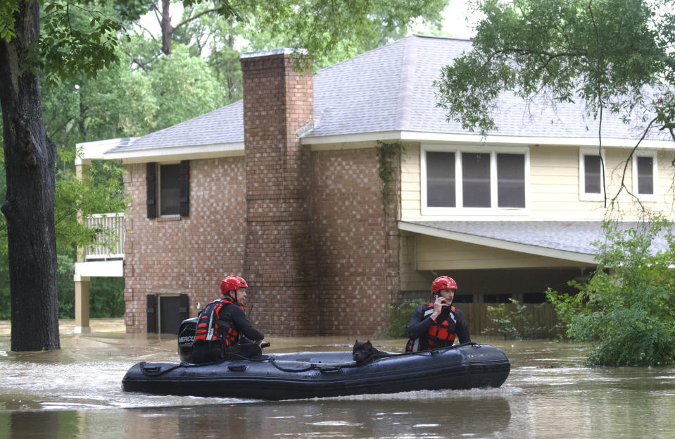 Emergency workers with Caney Creek Fire and Rescue carry a dog from a flooded area in the River Plantation area of Conroe, Texas Friday, May 3, 2024. (Jason Fochtman/Houston Chronicle via AP)/
