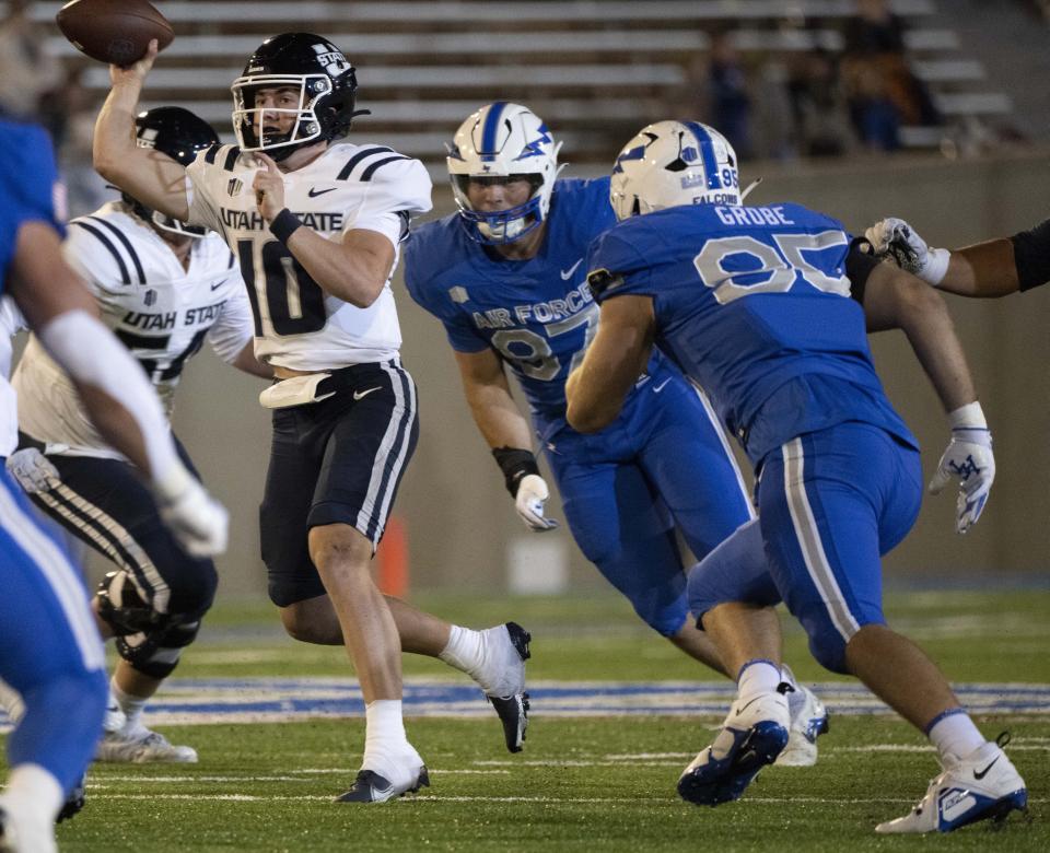 Air Force defensive lineman Caden Blum (87) and defensive end Daniel Grobe (95) pressure Utah State quarterback McCae Hillstead (10) during the second half of an NCAA college football game in Air Force Academy, Colo., Friday, Sept. 15, 2023. | Christian Murdock/The Gazette via AP