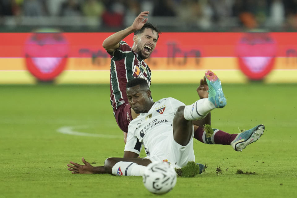 Leonel Quinonez of Ecuador's Liga Deportiva Universitaria, front, and Martinelli of Brazil's Fluminense fall while fighting for a ball during the Recopa Sudamericana first leg final soccer match at Rodrigo Paz Delgado stadium in Quito, Ecuador, Thursday, Feb. 22, 2024. (AP Photo/Dolores Ochoa)