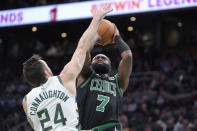 Boston Celtics guard Jaylen Brown (7) shoots as Milwaukee Bucks guard Pat Connaughton (24) defends during the first half of an NBA basketball game Wednesday, March 20, 2024, in Boston. (AP Photo/Steven Senne)