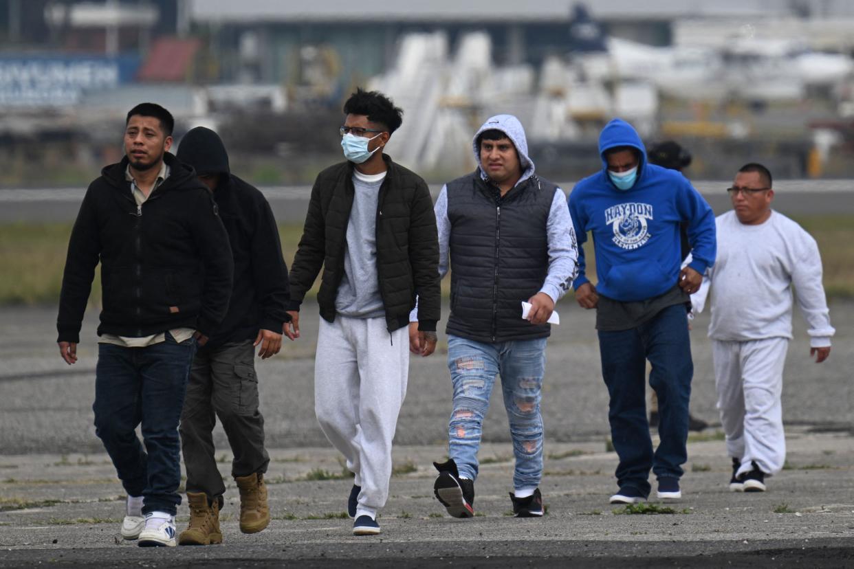 Guatemalan migrants deported from the United States walk on the airport runway upon their arrival at the Air Force Base in Guatemala City on Thursday.