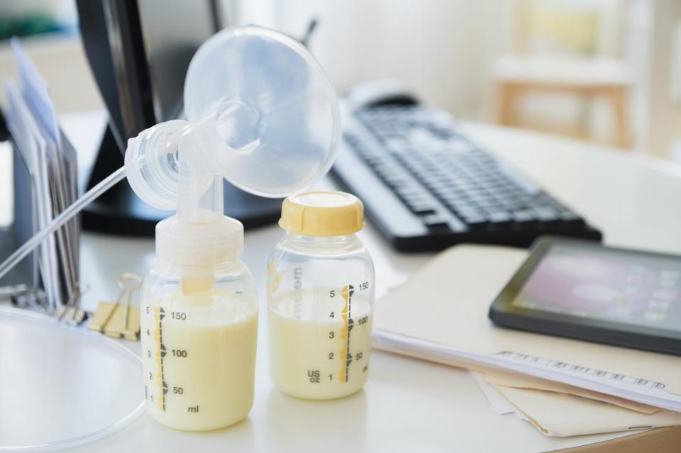 An image of a breast pump and bottles on office desk.