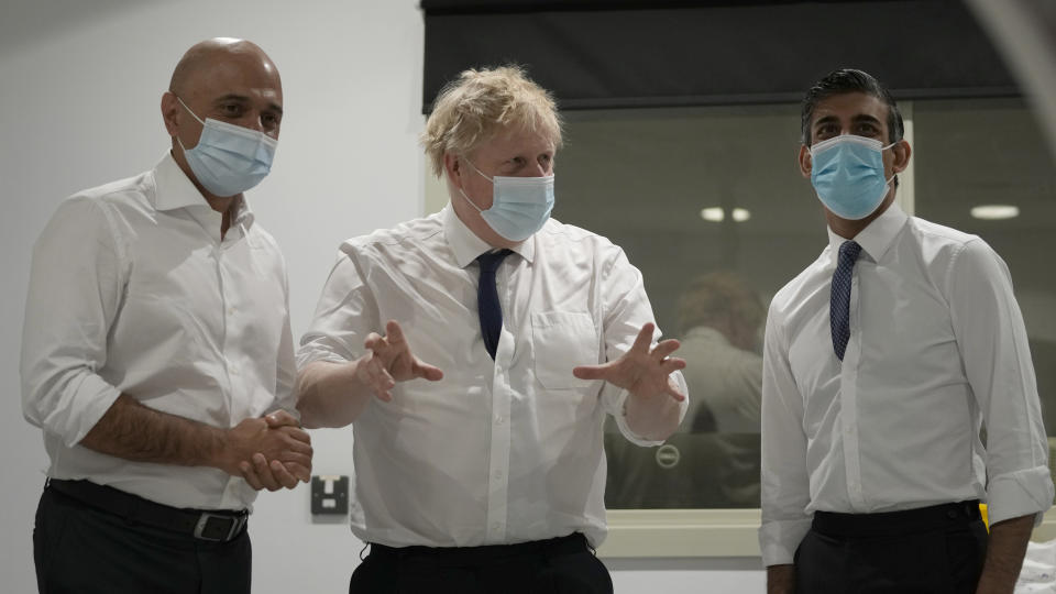 FILE - Britain's Prime Minister Boris Johnson, center, Rishi Sunak, Chancellor of the Exchequer, right, and Sajid Javid, Secretary of State for Health and Social Care speak together as they look at a CT scanner during a visit to the New Queen Elizabeth II Hospital, Welwyn Garden City, England, on April 6, 2022. Two of Britain’s most senior Cabinet ministers have quit, a move that could spell the end of Prime Minister Boris Johnson’s leadership after months of scandals. Treasury chief Rishi Sunak and Health Secretary Sajid Javid resigned within minutes of each other. (AP Photo/Frank Augstein, File