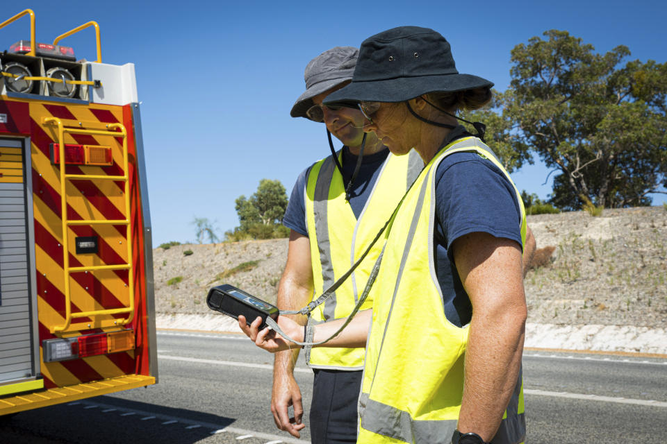 In this photo provided by the Department of Fire and Emergency Services, its members search for a radioactive capsule believed to have fallen off a truck being transported on a freight route on the outskirts of Perth, Australia, Saturday, Jan. 28, 2023. A mining corporation on Sunday apologized for losing the highly radioactive capsule over a 1,400-kilometer (870-mile) stretch of Western Australia, as authorities combed parts of the road looking for the tiny but dangerous substance. (Department of Fire and Emergency Services via AP)