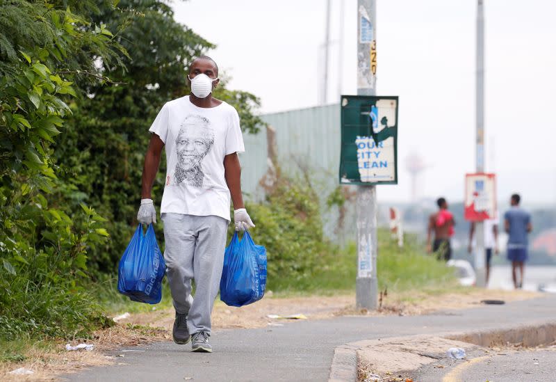 A man carries home groceries during a nationwide 21 day lockdown in an attempt to contain the coronavirus disease (COVID-19) outbreak in Umlazi township near Durban