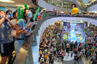 People react as they watch Siobhan Bernadette Haughey of Hong Kong swim in the women's 100-meter freestyle final at the 2020 Summer Olympics, at a shopping mall in Hong Kong, Friday, July 30, 2021. Haughey, born in Hong Kong four months after the 1997 handover, now has two silver medals from Tokyo, becoming the city’s first-ever multiple medalist. Hong Kong’s haul of treasure from Tokyo, with a gold also won in men’s fencing, outshines the one gold, one silver and one bronze that Hong Kong accumulated through all of its previous Olympic appearances since its 1952 debut at the Helsinki Games. (AP Photo/Vincent Yu)