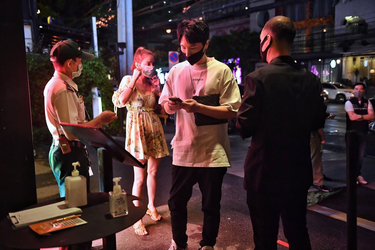 A couple checks into a bar using a tracking app as restrictions to halt the spread of the coronavirus are eased in Bangkok on July 1, 2020.