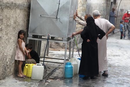 Residents fill water containers in Aleppo, Syria September 15, 2015. REUTERS/Abdalrhman Ismail/Files