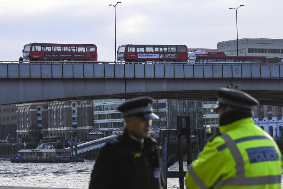Buses and cars remain on London Bridge in London, Sunday Dec. 1, 2019, after it being closed to traffic and public after an attack on Friday. Authorities in Britain say the convicted terrorist who stabbed to death two people and wounded three others in a knife attack Friday had been let out of prison in an automatic release program. (AP Photo/Alberto Pezzali)