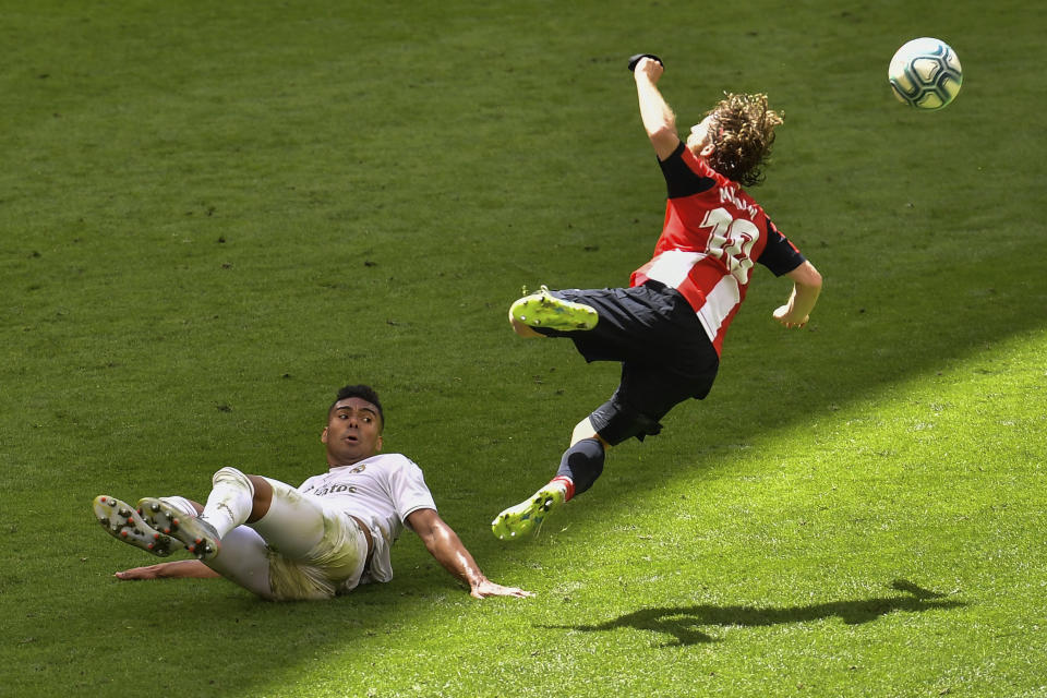 Iker Muniain del Athletic Bilbao es derribado por Casemiro del Real Madrid en el partido de la Liga de España en Bilbao, el domingo 5 de julio de 2020. (AP Foto/Alvaro Barrientos)