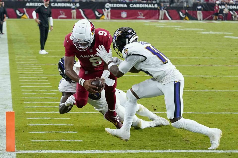 Arizona Cardinals quarterback Joshua Dobbs (9) is stopped by Baltimore Ravens cornerback Arthur Maulet (10) and linebacker Patrick Queen (6) in a failed attempt to score a two-point conversion during the second half of an NFL football game Sunday, Oct. 29, 2023, in Glendale, Ariz. (AP Photo/Ross D. Franklin)