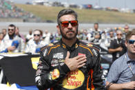 Martin Truex Jr. stands during the national anthem before a NASCAR Cup Series auto race at Kansas Speedway in Kansas City, Kan., Sunday, Sept. 10, 2023. (AP Photo/Colin E. Braley)