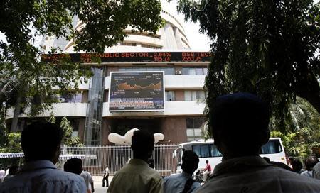 People look at a large screen displaying India's benchmark share index on the facade of the Bombay Stock Exchange (BSE) building in Mumbai May 19, 2009. REUTERS/Punit Paranjpe