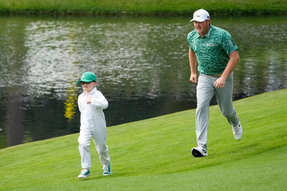 Apr 6, 2022; Augusta, Georgia, USA; Jason Kokrak and his son, Declan, 5, run to the cup on the no. 4 green to retrieve his ace during the Par 3 Contest at The Masters golf tournament at Augusta National Golf Club.