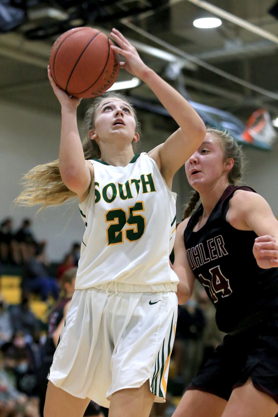 Salina South's Lauren Harris (25) shoots past Buhler's Sammie Brooks (14) during their game Tuesday night, Dec. 7, 2021. Salina South defeated Buhler 60-50.