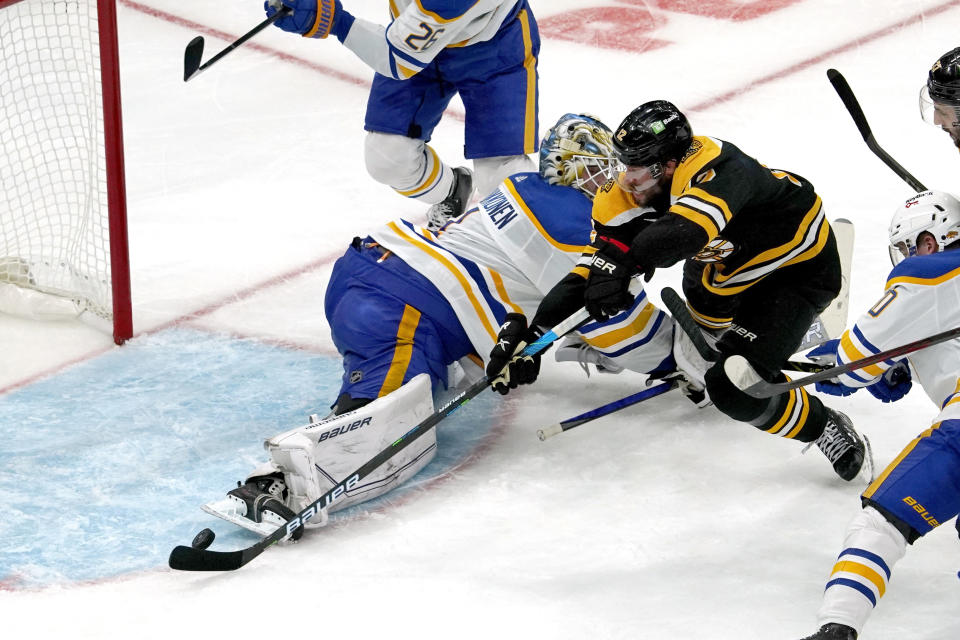 Boston Bruins center Craig Smith (12) beats Buffalo Sabres goaltender Ukko-Pekka Luukkonen (1) for a goal during the second period of an NHL hockey game, Saturday, Jan. 1, 2022, in Boston. (AP Photo/Mary Schwalm)