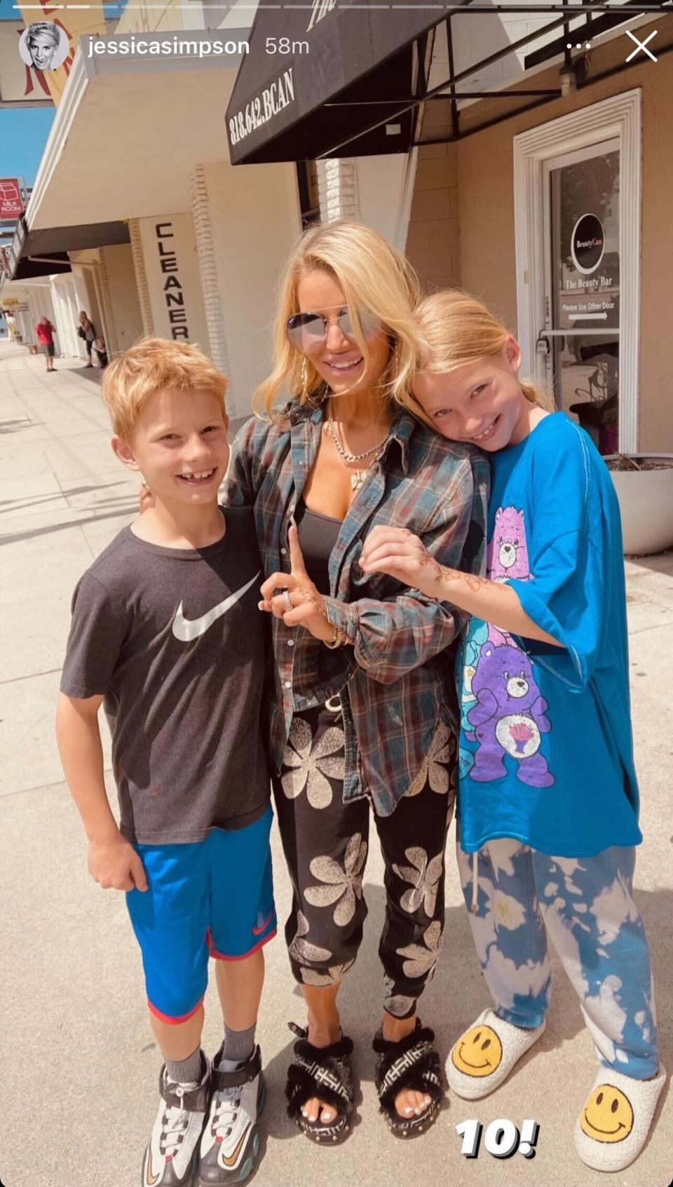 Jessica Simpson wearing a casual ensemble with slides while posing with her children Maxwell and Ace. - Credit: Instagram