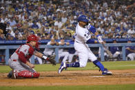 Los Angeles Dodgers' Mookie Betts drives in a run with a single during the fourth inning of the team's baseball game against the Los Angeles Angels on Friday, Aug. 6, 2021, in Los Angeles. (AP Photo/Marcio Jose Sanchez)