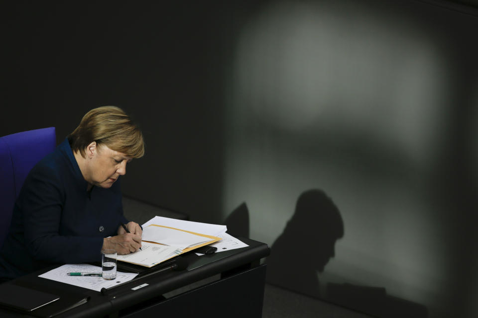 FILE - In this Wednesday, Oct. 17, 2018 file photo, German Chancellor Angela Merkel writes during a meeting of the German federal parliament, Bundestag, at the Reichstag building in Berlin, Germany. Angela Merkel will leave office in the coming months with her popularity intact, despite her party’s dismal election result. (AP Photo/Markus Schreiber, File)