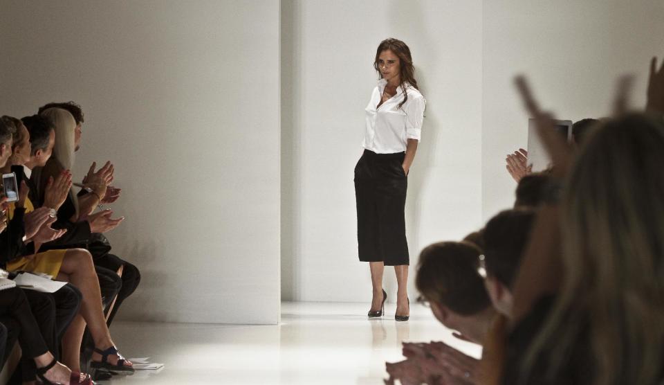 Victoria Beckham reacts to applause following the runway fashion show of her Spring 2014 collection on Sunday, Sept. 8, 2013 in New York. (AP Photo/Bebeto Matthews)