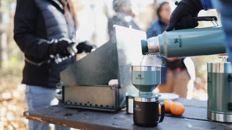 Pouring hot water from a stanley flask camping