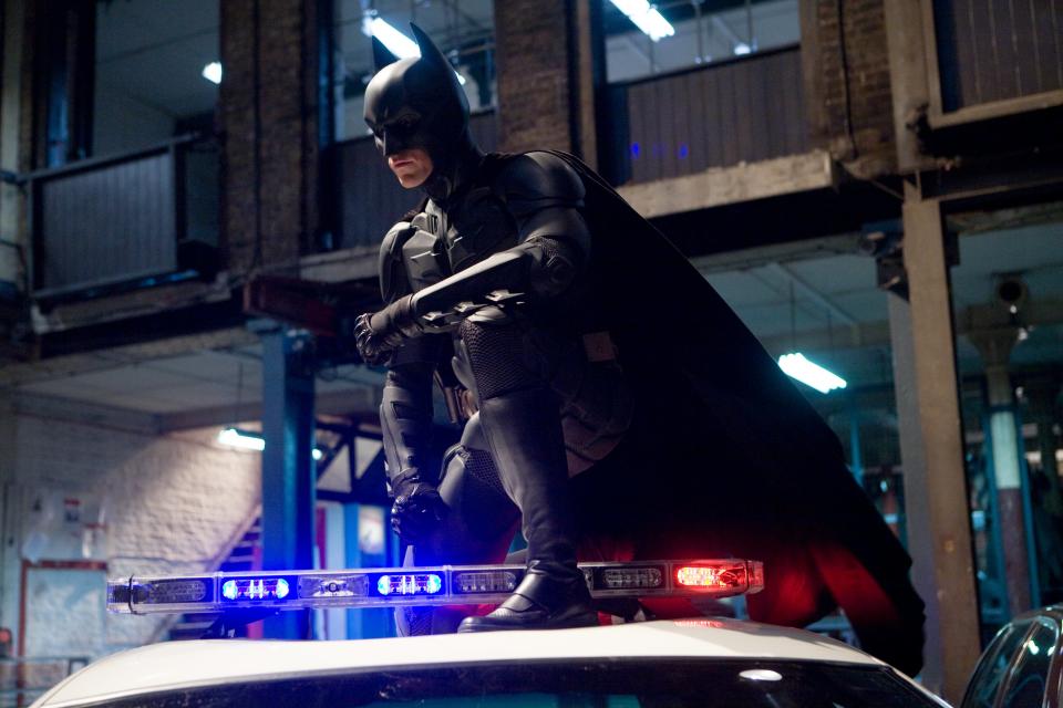 The Dark Knight - 

Full shot of Christian Bale as Batman crouching atop police car.