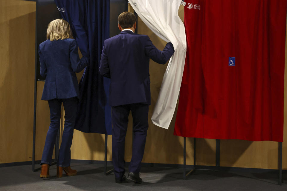 French President Emmanuel Macron and his wife Brigitte Macron enter a voting booth during the European election, Sunday, June 9, 2024 in Le Touquet-Paris-Plage, northern France. Polling stations opened across Europe on Sunday as voters from 20 countries cast ballots in elections that are expected to shift the European Union's parliament to the right and could reshape the future direction of the world's biggest trading bloc. (Hannah McKay/Pool via AP)